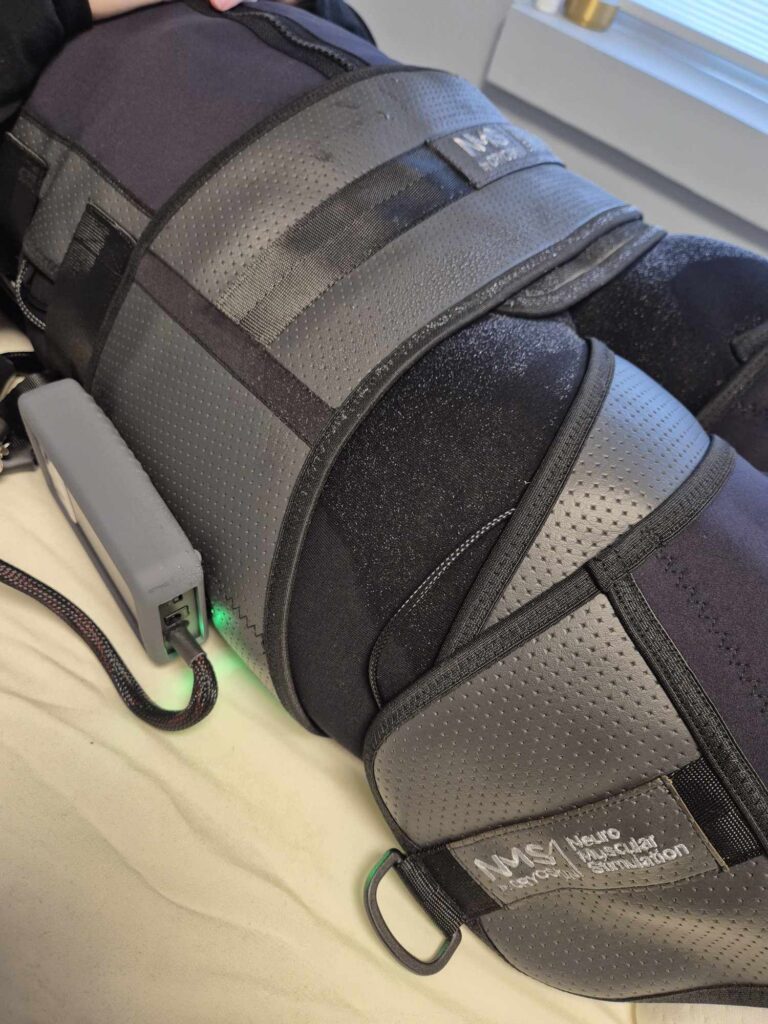 NMS dragt på ung kvinde. Til muskelopbyggende behandling. 30 minutter i dragten svarer til 30 minutters hård træning.